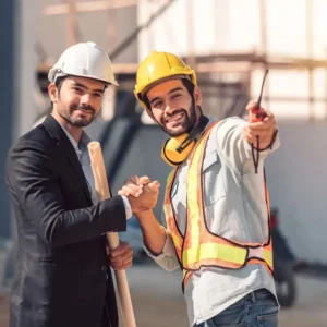 Two men shaking hands on a construction site smiling